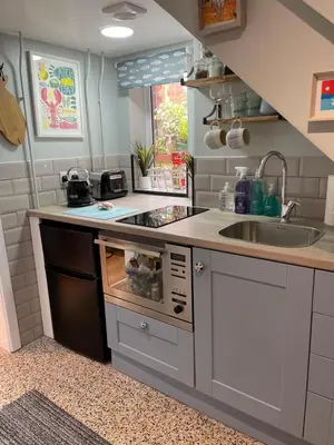 a kitchen with a sink and a stove top oven at Tiny Beach House in Saint Annes on the Sea
