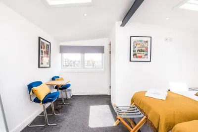 a room with two beds and chairs and a window at Liverpool Waterfront Stay, excellent location , parking available in Liverpool