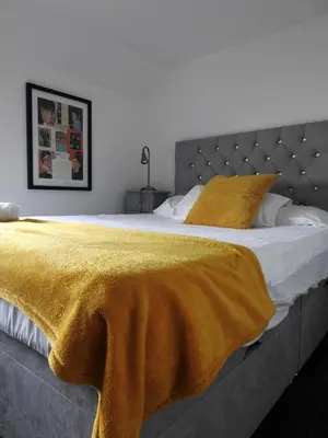 a bedroom with a bed with a yellow blanket on it at Liverpool Waterfront Stay, excellent location , parking available in Liverpool