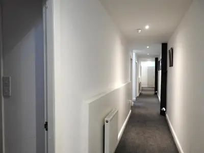 a hallway with white walls and a long corridor at Liverpool Waterfront Stay, excellent location , parking available in Liverpool