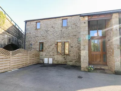 a brick building with a gate and a garage at 1 Netherbeck Barn in Carnforth