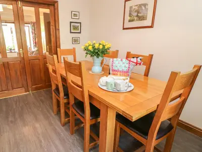 a dining room with a wooden table and chairs at 1 Netherbeck Barn in Carnforth