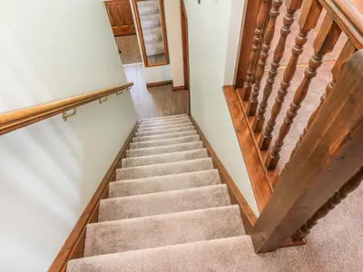 a staircase in a house with wooden railings at 1 Netherbeck Barn in Carnforth