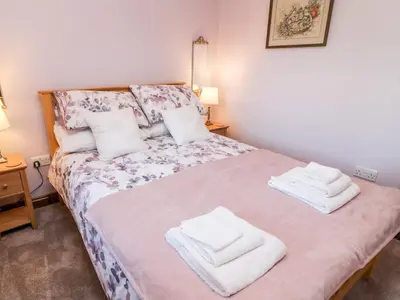 a bedroom with a bed with towels on it at 1 Netherbeck Barn in Carnforth