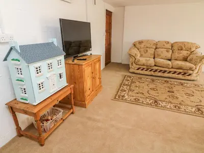 a living room with a couch and a television at 1 Netherbeck Barn in Carnforth