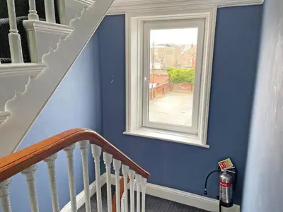 a staircase with a window in a blue wall at 1820 Boutique Rooms & Suites in Blackpool