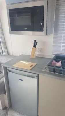 a kitchen with a counter with a microwave and a refrigerator at KINGDOM HOLIDAY PARK - Parrot in Millom