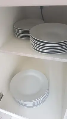 a stack of white plates sitting on a shelf at KINGDOM HOLIDAY PARK - Parrot in Millom