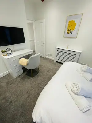 a bedroom with a bed and a desk and a television at Ivy Apartments by CityNest in Blackpool