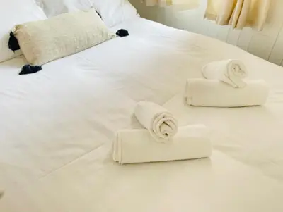 a white bed with towels on top of it at Ivy Apartments by CityNest in Blackpool