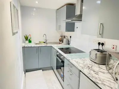 a kitchen with white cabinets and a counter top at Ivy Apartments by CityNest in Blackpool