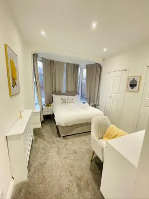 a white bedroom with a bed and a couch at Ivy Apartments by CityNest in Blackpool