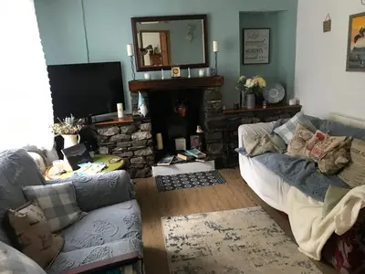 a living room with a couch and a fireplace at Saltcotes Farm in Ulverston