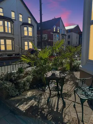 a patio with two chairs and a table with plants at Granada Apartments at Pleasure Beach in Blackpool