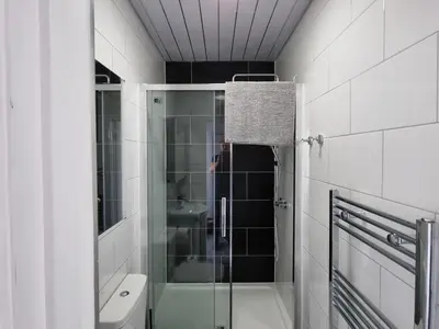 a man taking a picture of a bathroom with a shower at Granada Apartments at Pleasure Beach in Blackpool