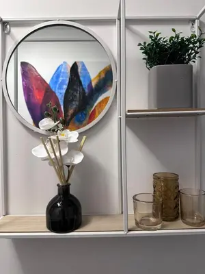a shelf with a mirror and a vase with flowers at Granada Apartments at Pleasure Beach in Blackpool