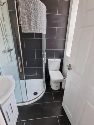 a bathroom with a toilet and a glass shower at Granada Apartments at Pleasure Beach in Blackpool