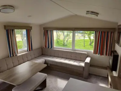 a living room with a couch and two windows at Vault 21 in Millom
