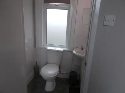 a small bathroom with a toilet and a sink at Kelso House holiday flats in Blackpool
