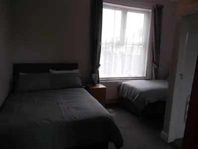 a bedroom with two beds and a window at Kelso House holiday flats in Blackpool