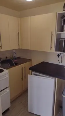 a kitchen with white cabinets and a counter top at The Kathrene Second Floor Sea View in Fleetwood