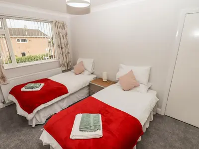 two beds in a small room with a window at Spring Close in Southport