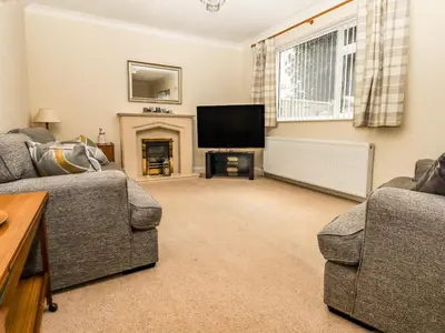 a living room with two couches and a flat screen tv at Spring Close in Southport
