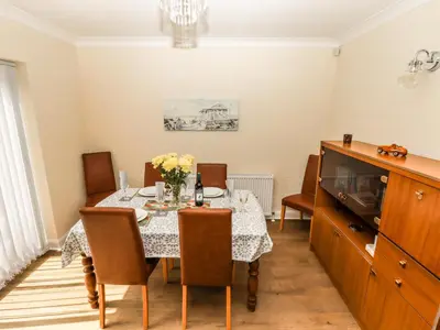 a dining room with a table and a tv at Spring Close in Southport