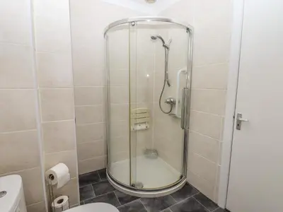 a shower with a glass door in a bathroom at Spring Close in Southport