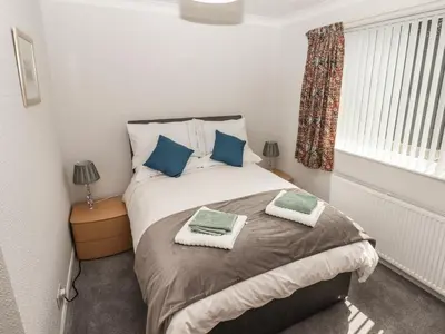 a bedroom with a bed with two towels on it at Spring Close in Southport