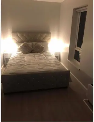 a bedroom with a bed with two lights on it at The Bungaloaf in Walton on the Hill