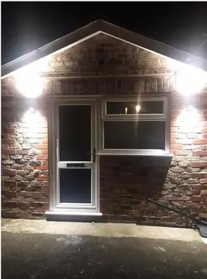 a brick house with two windows at night at The Bungaloaf in Walton on the Hill