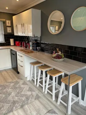 a kitchen with a large wooden table and stools at Seagull’s View in Lytham St Annes