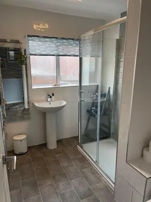a bathroom with a glass shower and a sink at Seagull’s View in Lytham St Annes