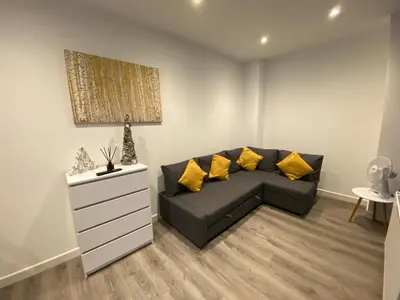 a living room with a black couch and yellow pillows at Blackpool Abode - 20 Bairstow Street in Blackpool