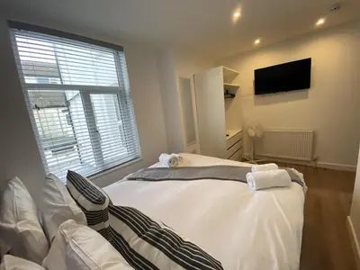 a bedroom with a white bed and a tv at Blackpool Abode - 20 Bairstow Street in Blackpool