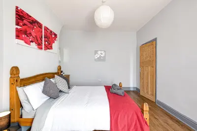 a bedroom with a bed with a red blanket at Knoclaid Sparkle Stays in Liverpool