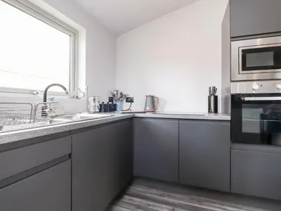 a white kitchen with a sink and a microwave at Box Tree Escapes in Lancaster