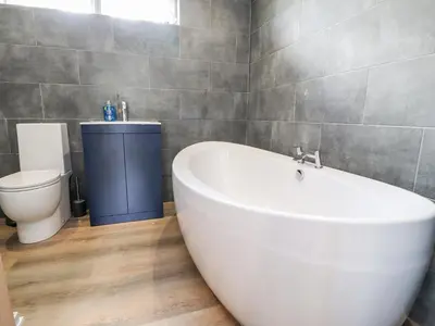 a bathroom with a white tub and a toilet at Box Tree Escapes in Lancaster