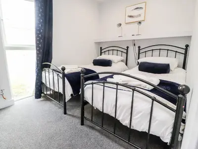 two iron beds in a bedroom with a window at Box Tree Escapes in Lancaster