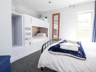 a white bedroom with a bed with towels on it at Box Tree Escapes in Lancaster