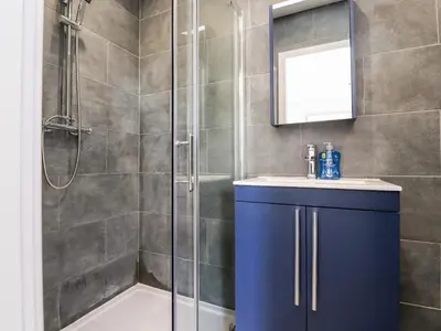 a bathroom with a shower and a sink and a mirror at Box Tree Escapes in Lancaster