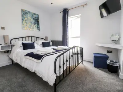 a bedroom with a bed with white sheets and blue pillows at Box Tree Escapes in Lancaster