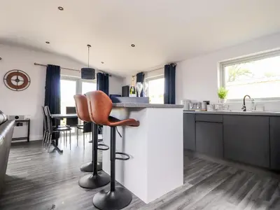 a kitchen with a counter and a bar with stools at Box Tree Escapes in Lancaster