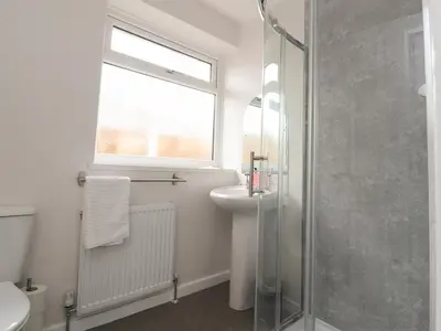 a bathroom with a sink and a glass shower at Kings Walk in Cleveleys