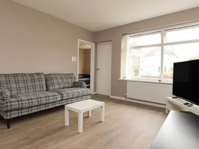 a living room with a couch and a tv at Kings Walk in Cleveleys
