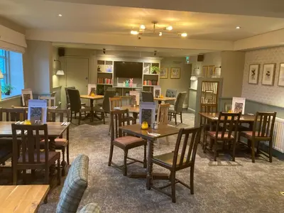 a dining room with wooden tables and chairs at The Stork Hotel in Lancaster