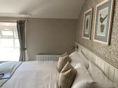 a bedroom with a white bed with two pillows at The Stork Hotel in Lancaster