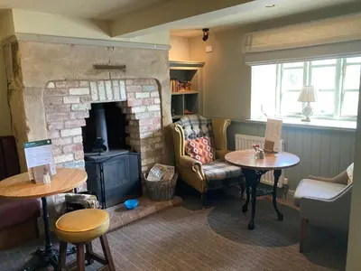 a living room with a fireplace and a couch and tables at The Stork Hotel in Lancaster
