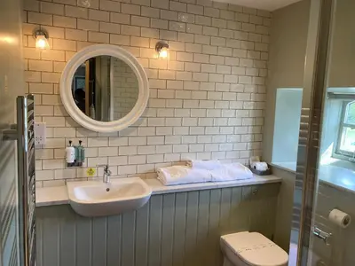 a bathroom with a sink and a mirror and a toilet at The Stork Hotel in Lancaster